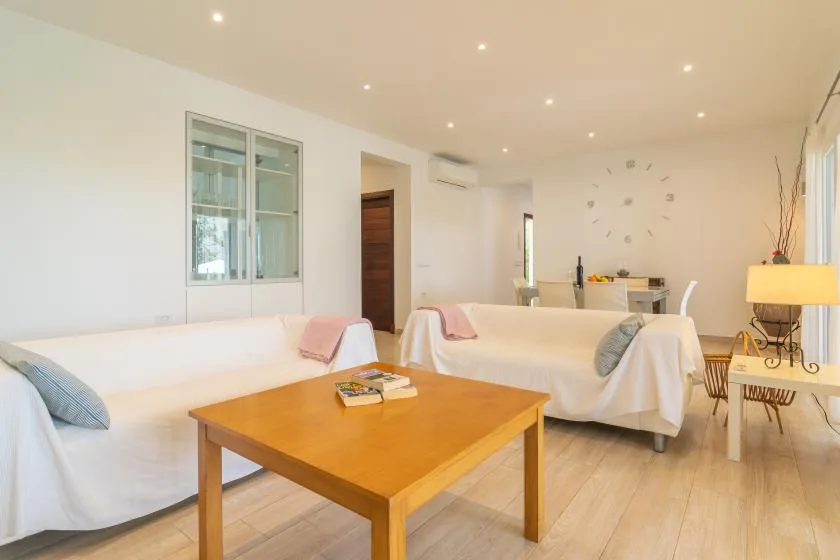Una sala luminosa con asientos dispuestos alrededor de una mesa de centro de madera.