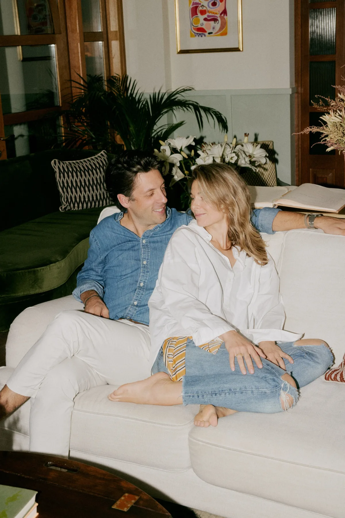Dos personas sentadas juntas en una sala de estar.
