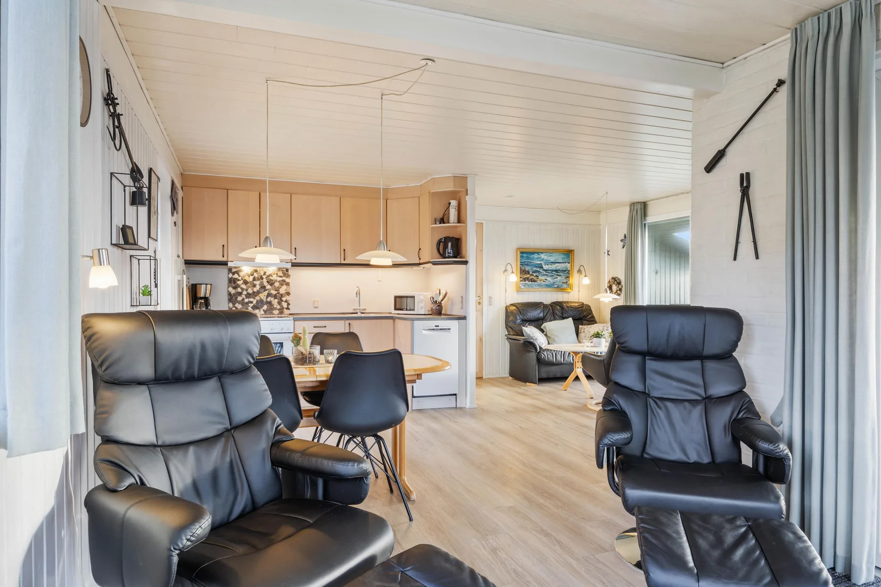 A living room opens into a kitchen, with seating and a dining area.