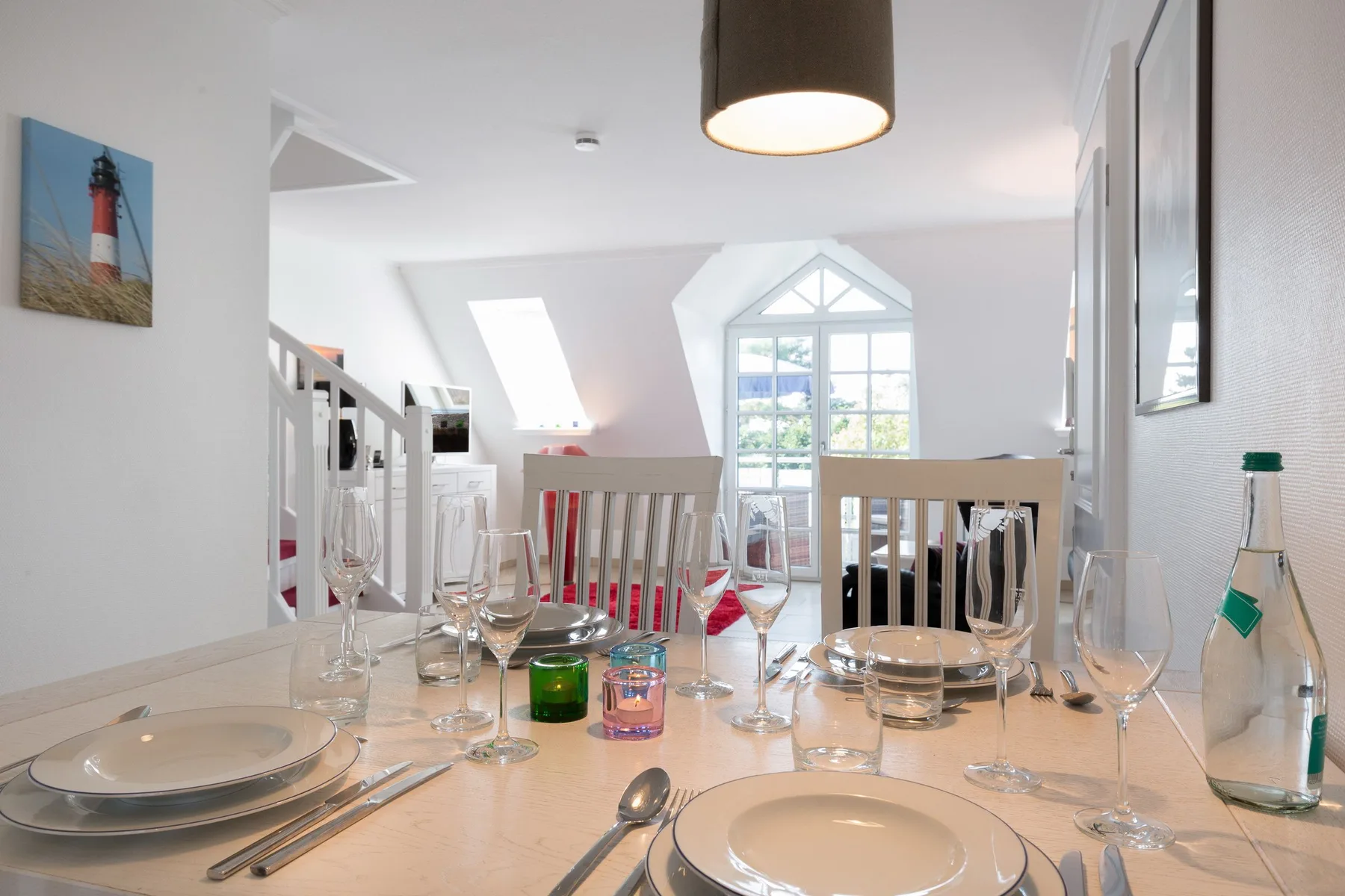 Un comedor con una mesa puesta junto a una ventana grande.