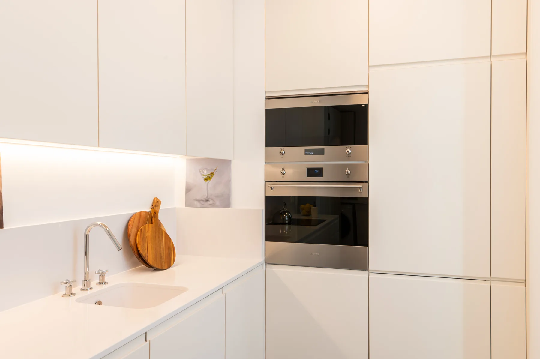 A bright modern kitchen with a sink and built-in appliances.