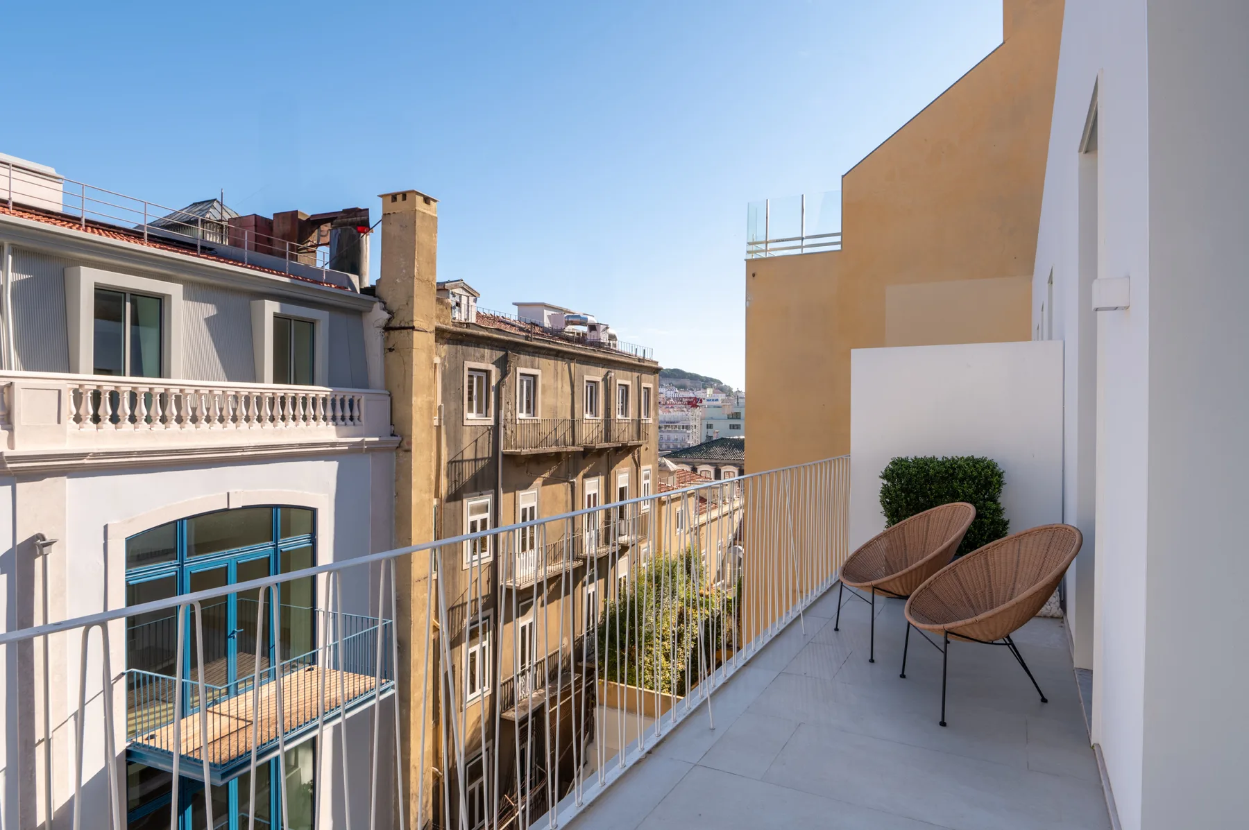 Un balcón estrecho con asientos da a los edificios cercanos de la ciudad.