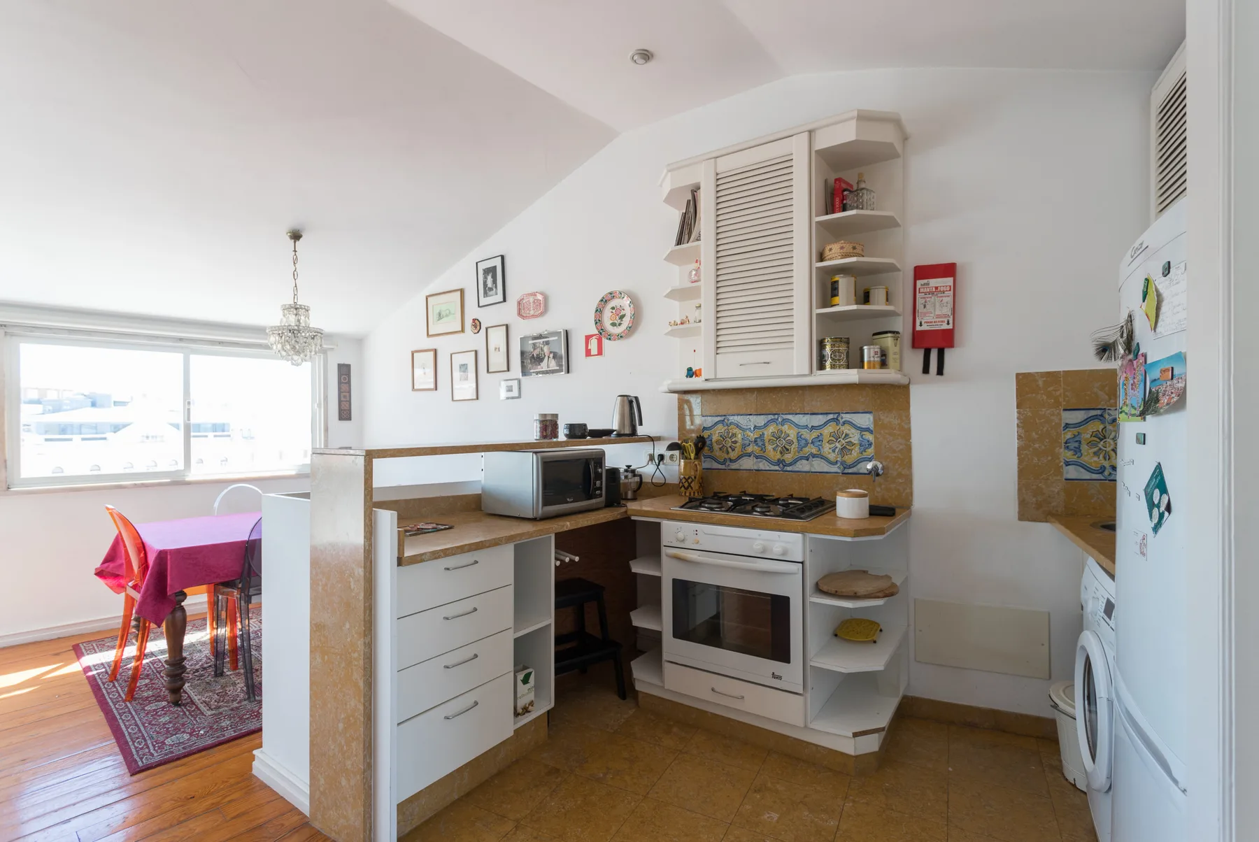 Una cocina con zona de comedor junto a una ventana grande.