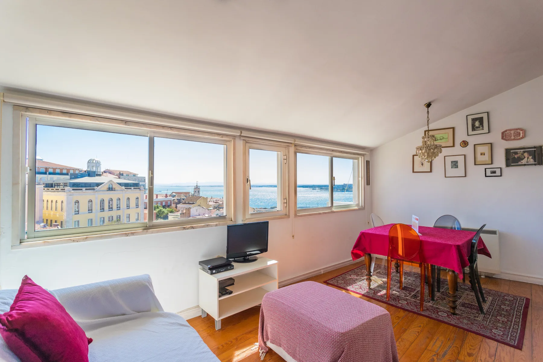 Una luminosa sala de estar y comedor con grandes ventanas con vistas al agua.