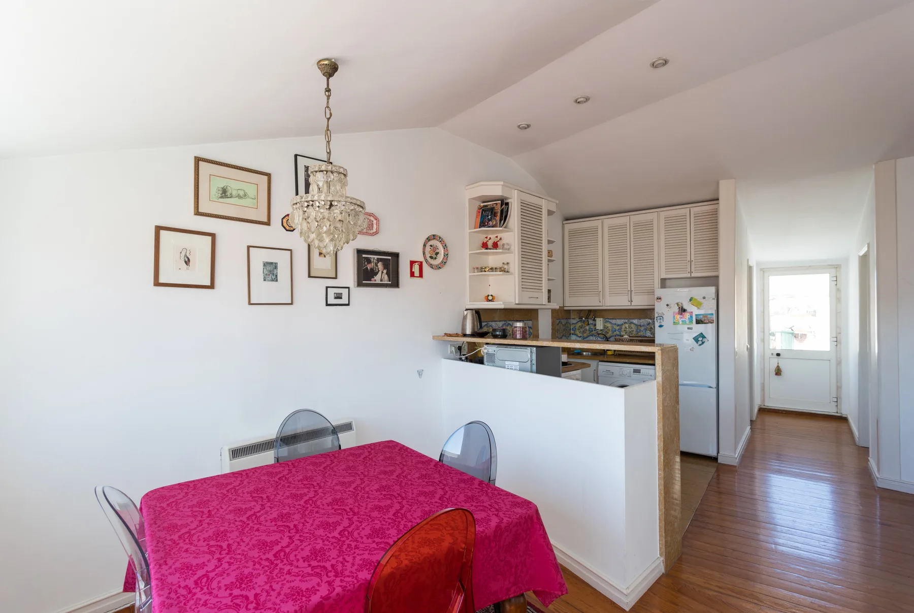 Comedor con un mantel llamativo junto a una cocina abierta.