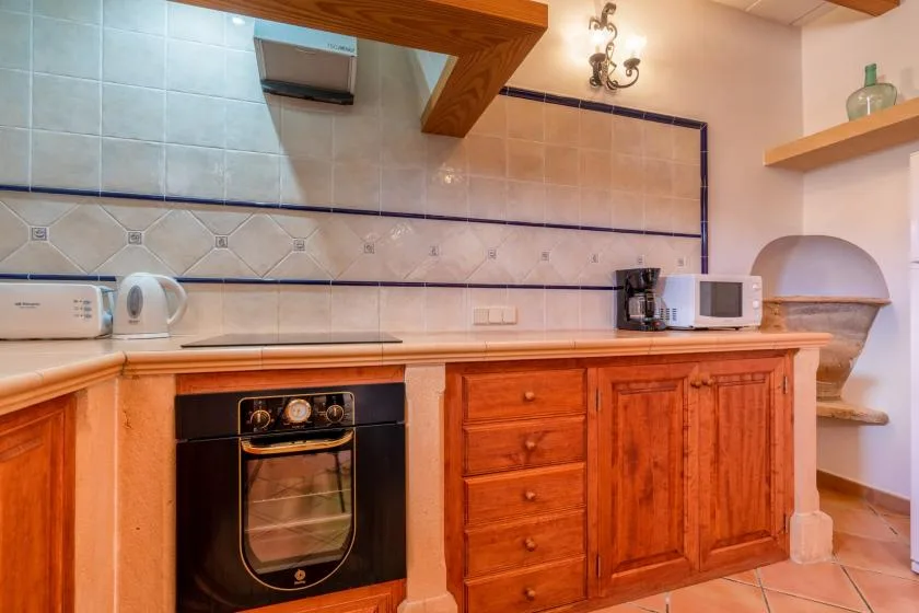 A kitchen with wooden cabinets, a built-in oven, and countertop appliances.