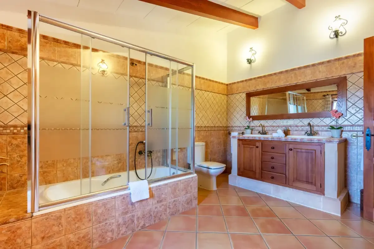 A spacious bathroom with a tiled shower, bathtub, and double vanity.