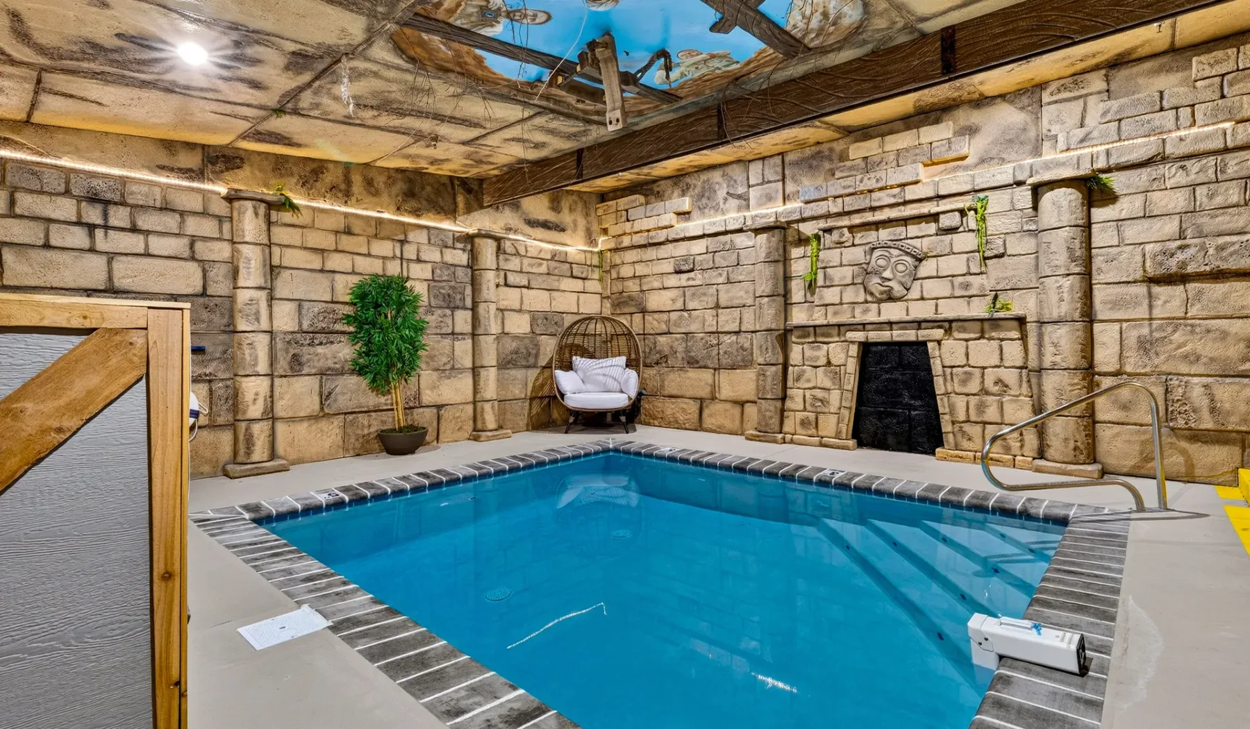 An indoor swimming pool with stone walls and a decorative ceiling.