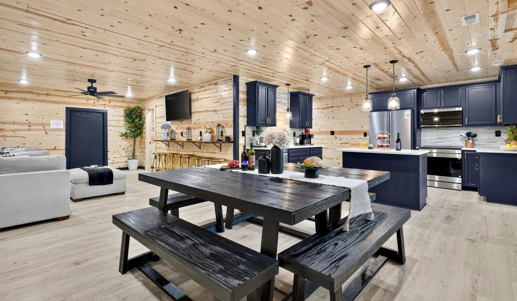A spacious kitchen and dining area with a dark table and open seating.
