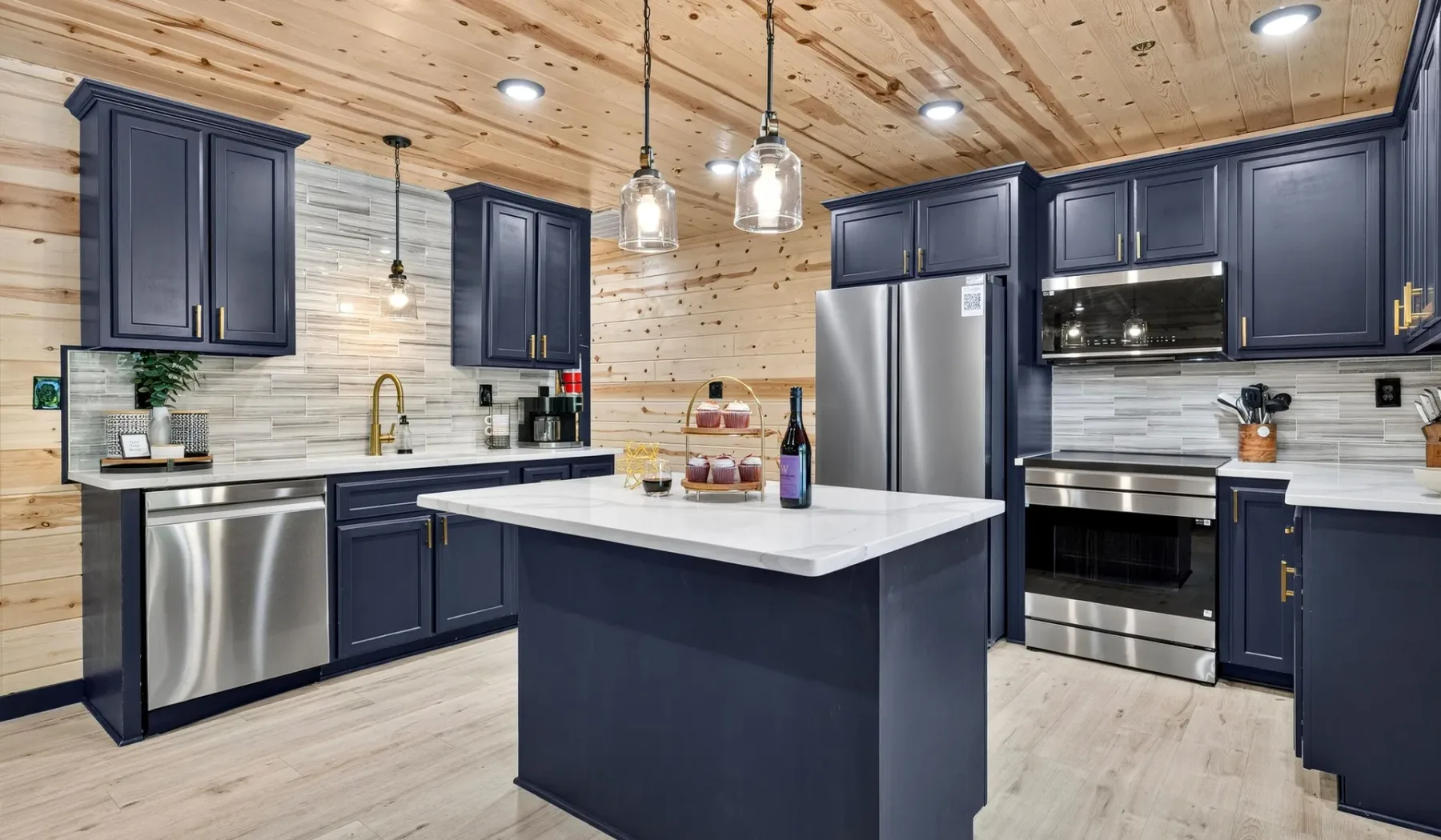 A spacious kitchen with a central island, dark cabinets, and stainless steel appliances.
