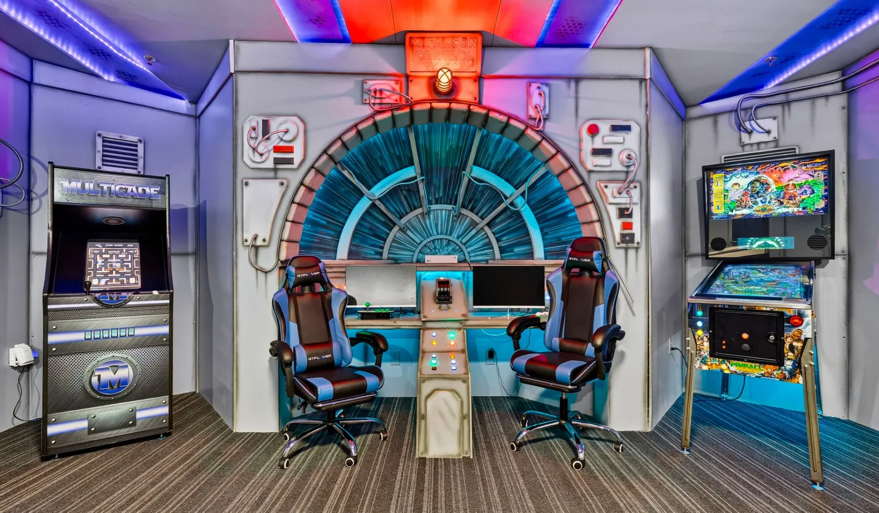 A brightly lit arcade room with gaming machines and a central control console.
