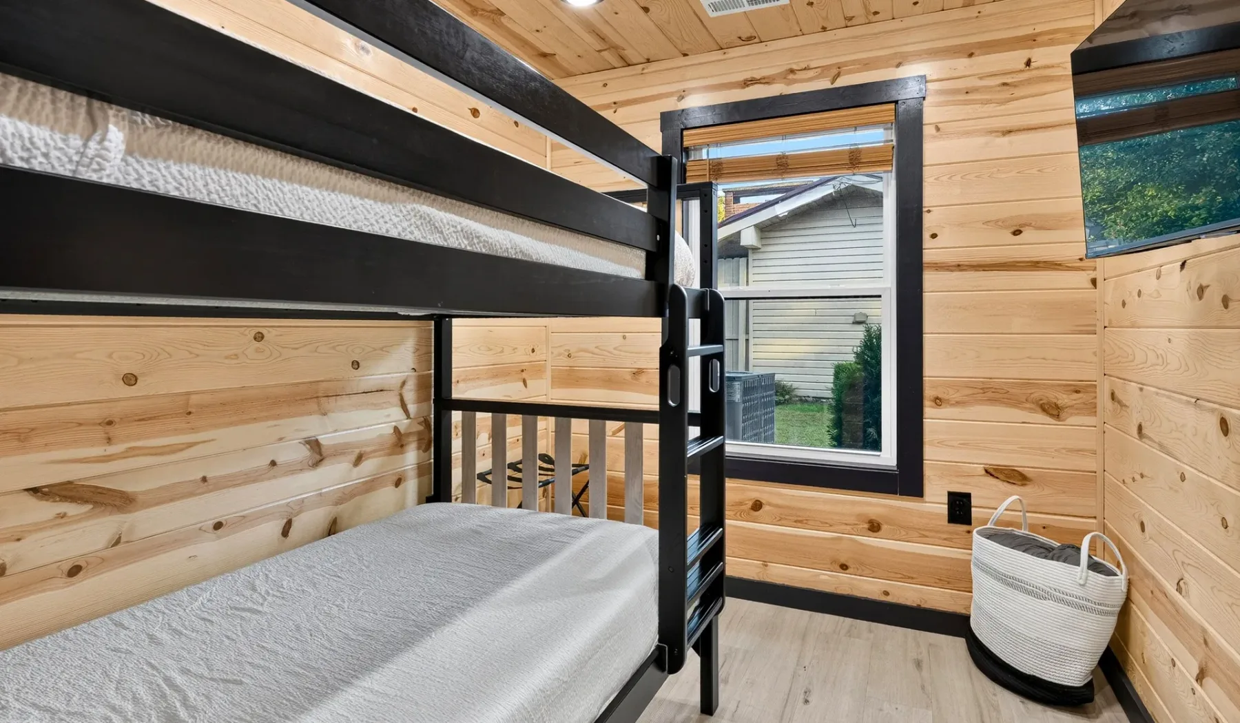 A wood-paneled bedroom with bunk beds and a window.