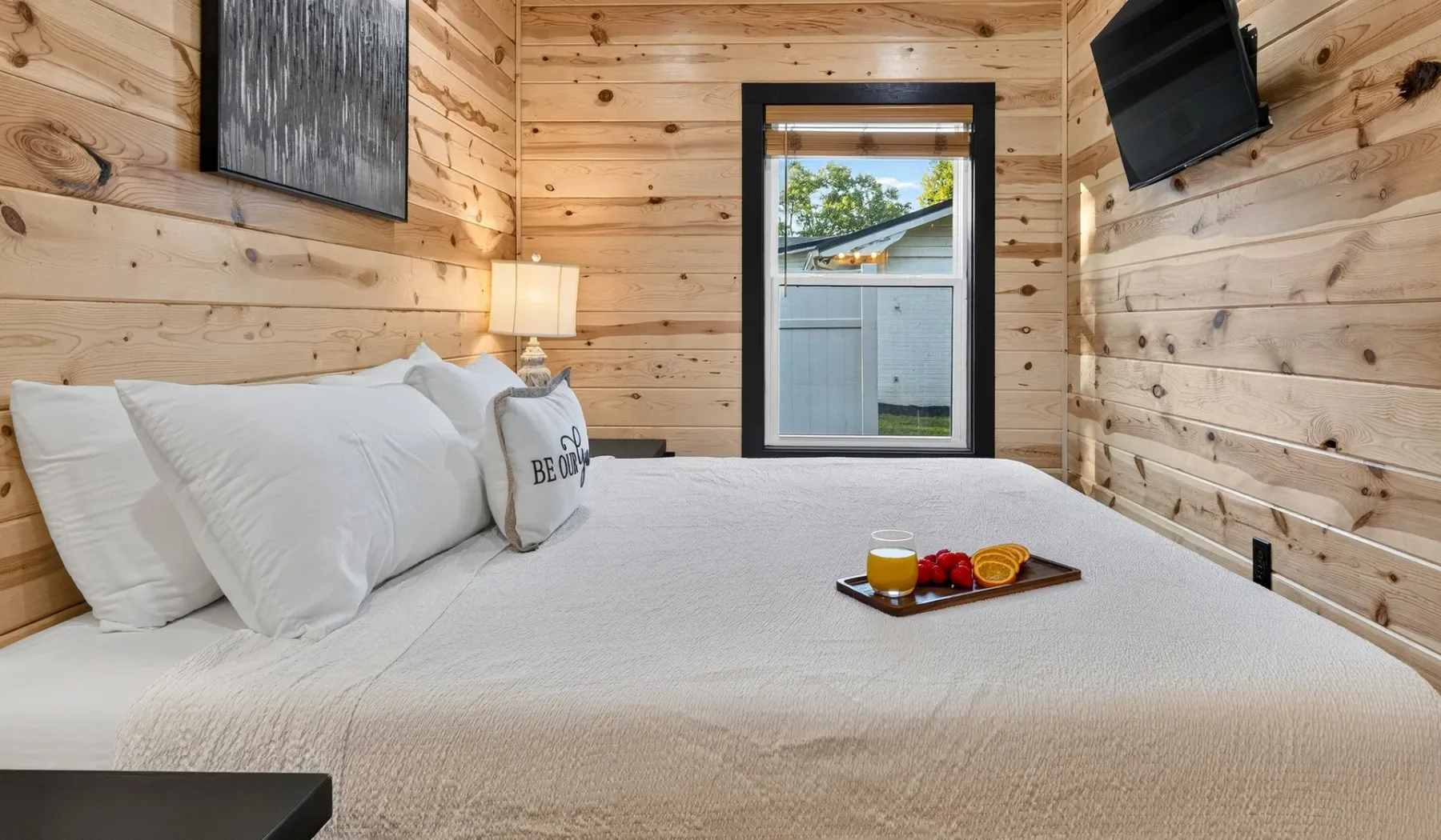 A bedroom with a large bed and wood-paneled walls.