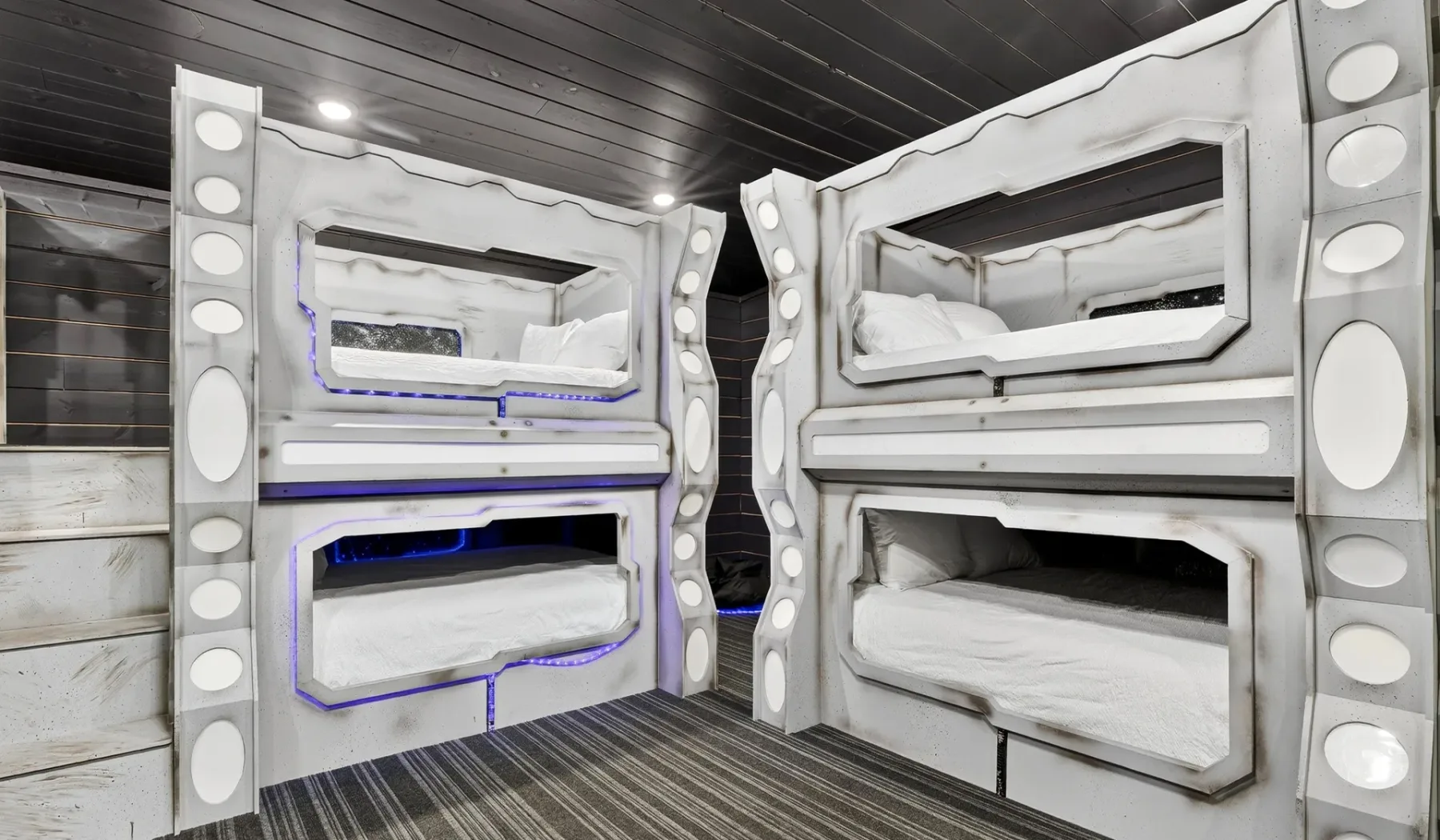 A room with built-in bunk beds and dark wood flooring.