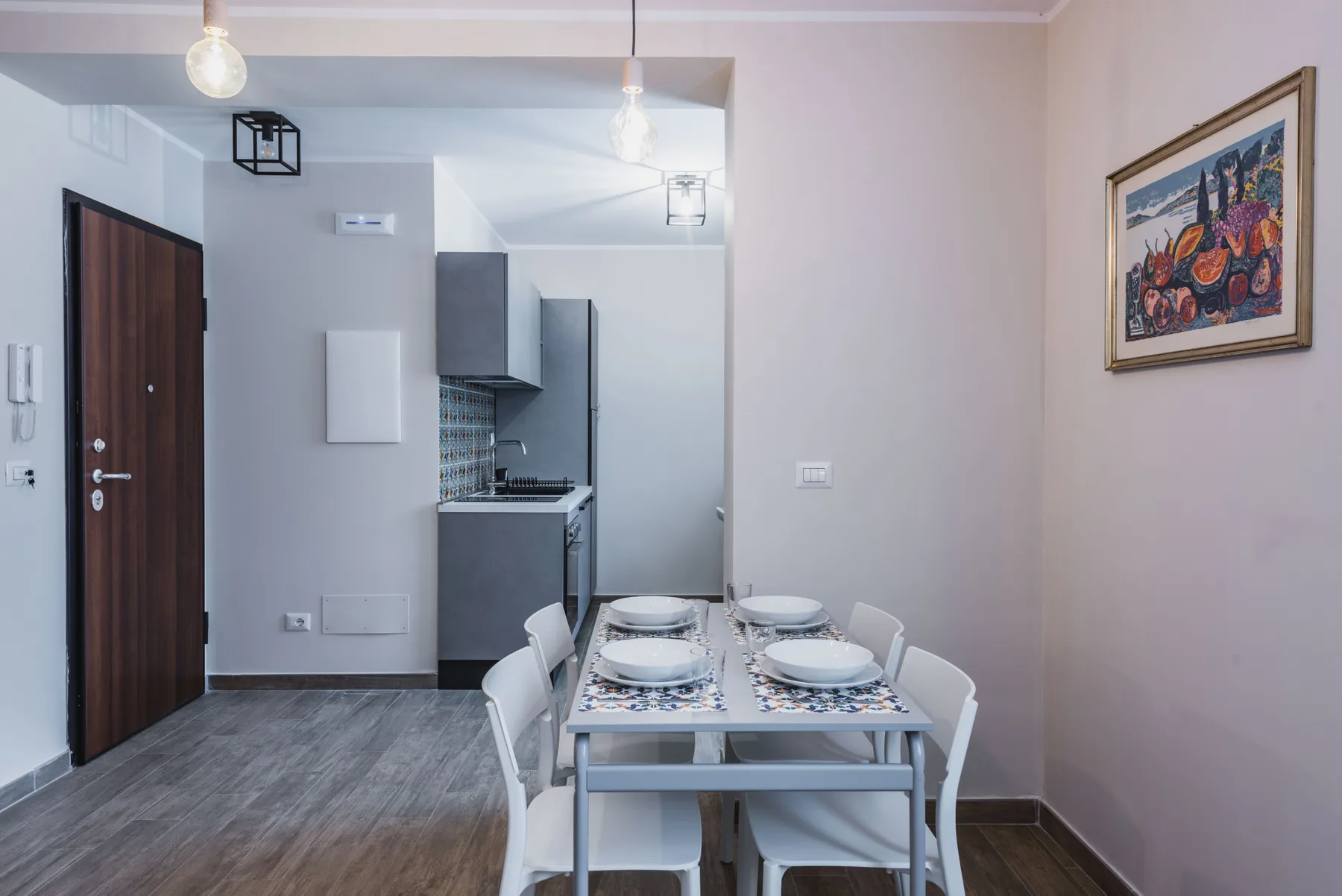 Comedor con una mesa puesta junto a una cocina compacta.
