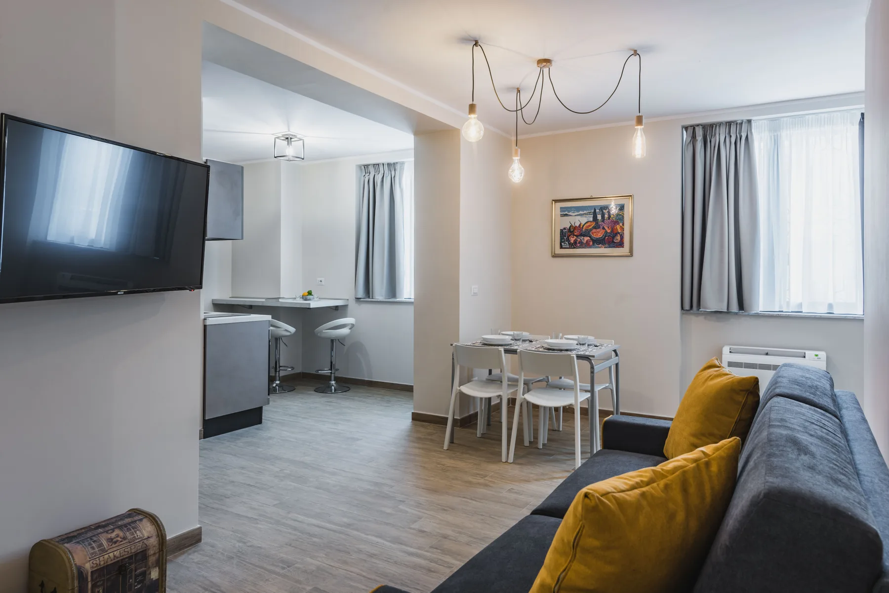 Una sala de estar y comedor con televisor, mesa y sofá.