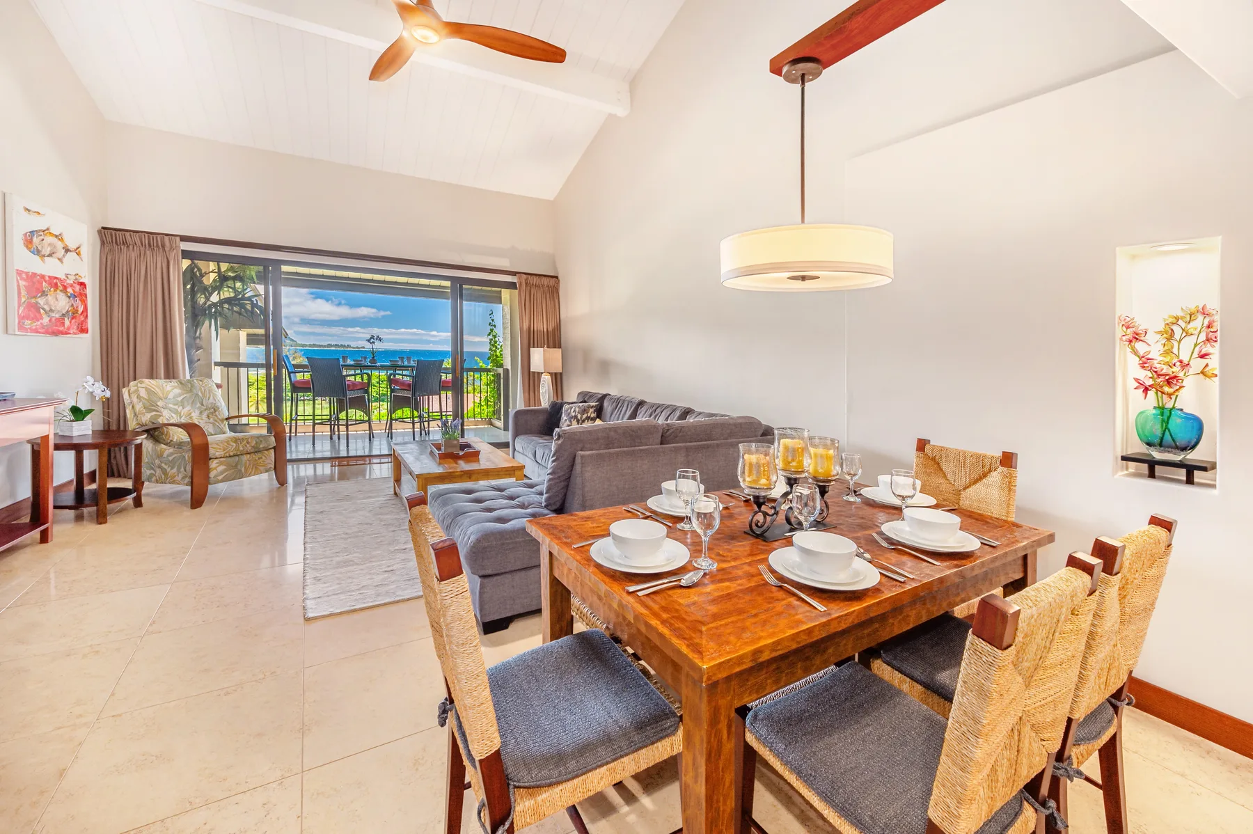 A bright living and dining area opens onto a balcony through sliding glass doors.