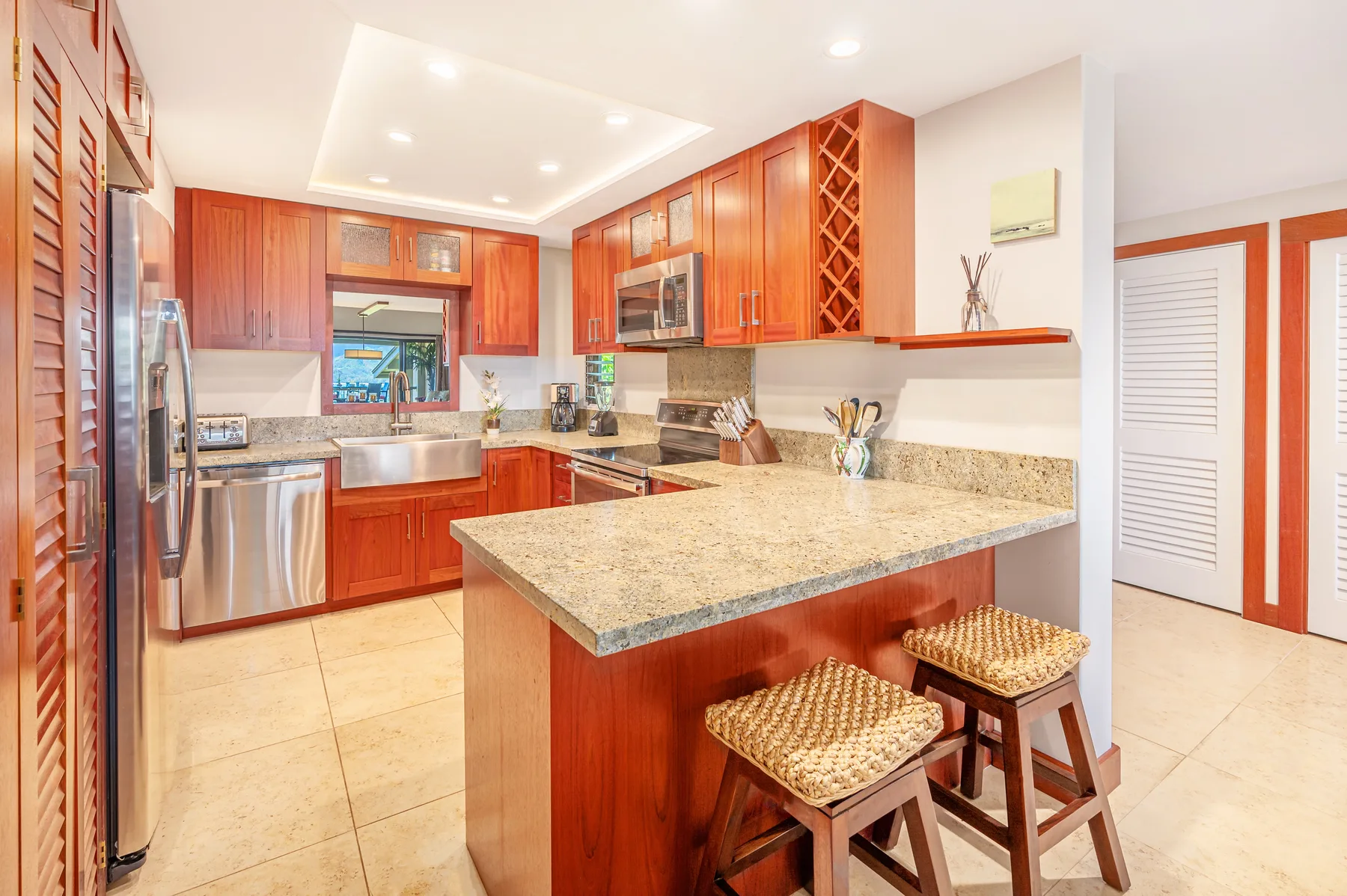 A bright kitchen with wooden cabinetry and a central island with seating.