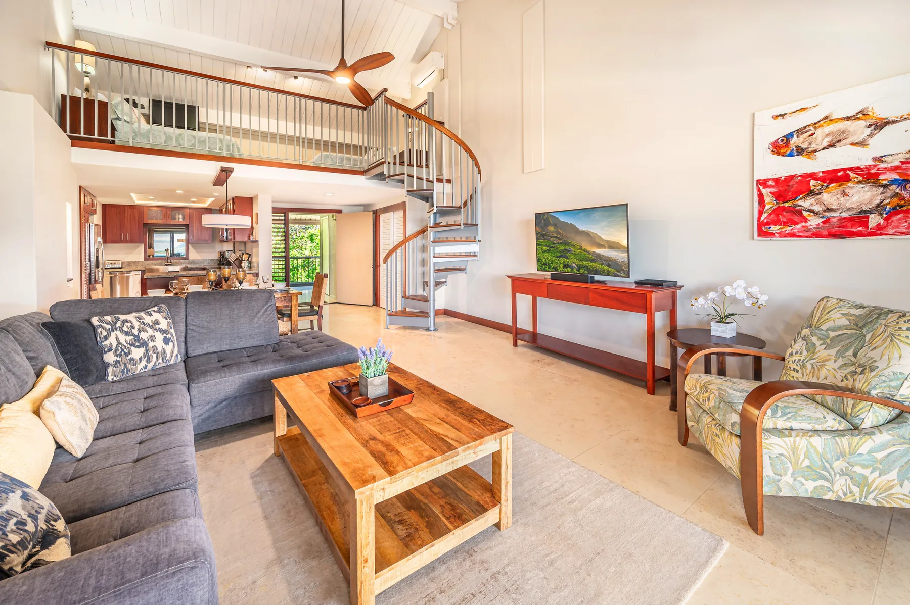 A living room with a sofa, wooden coffee table, and staircase to an upper level.