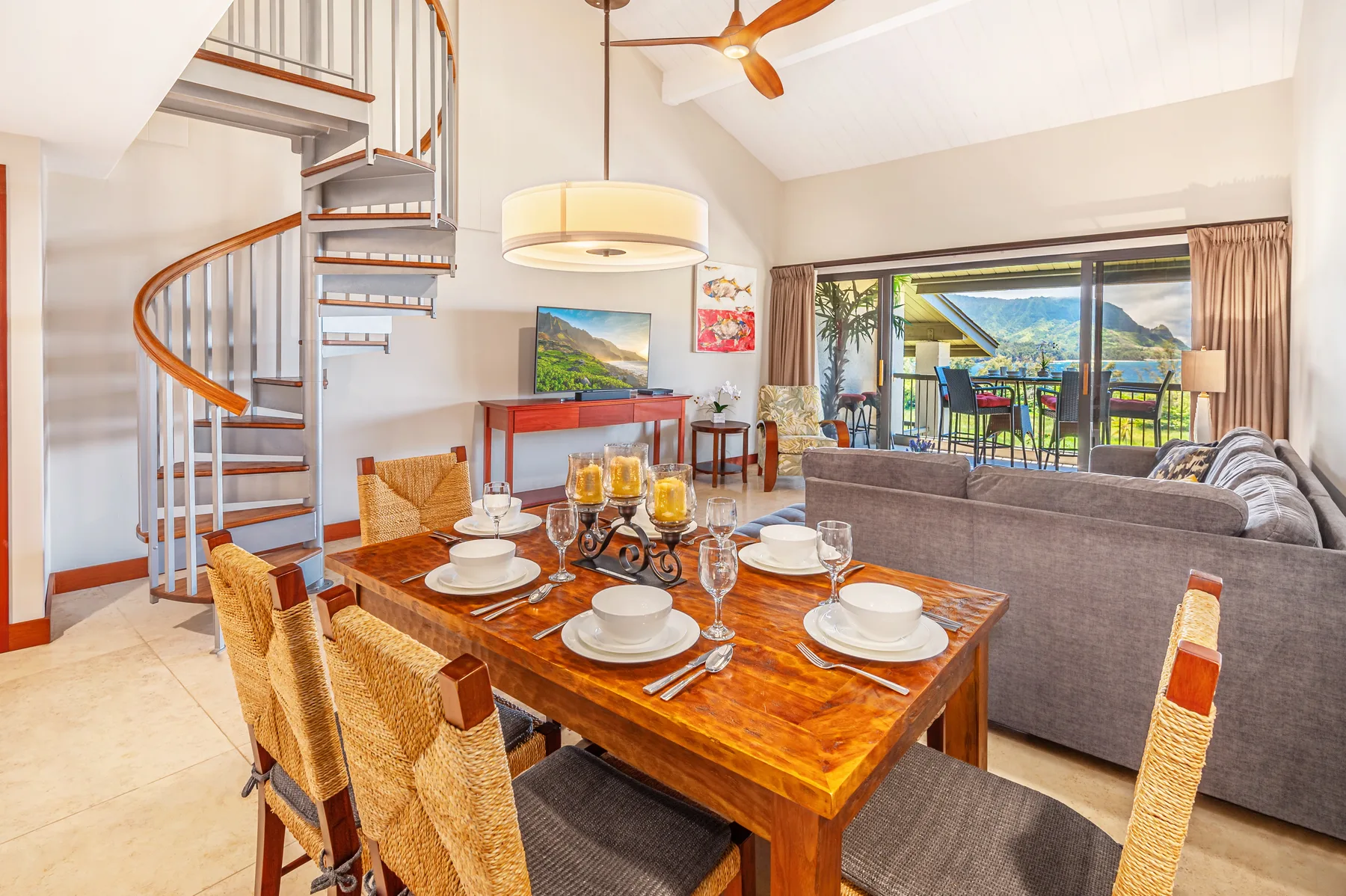 An open-plan living and dining room with a set dining table and sliding glass doors.