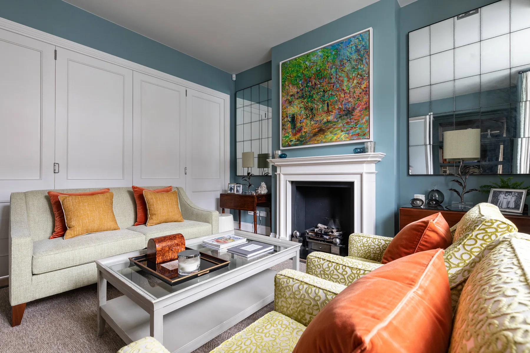 A living room with seating arranged around a coffee table and fireplace.