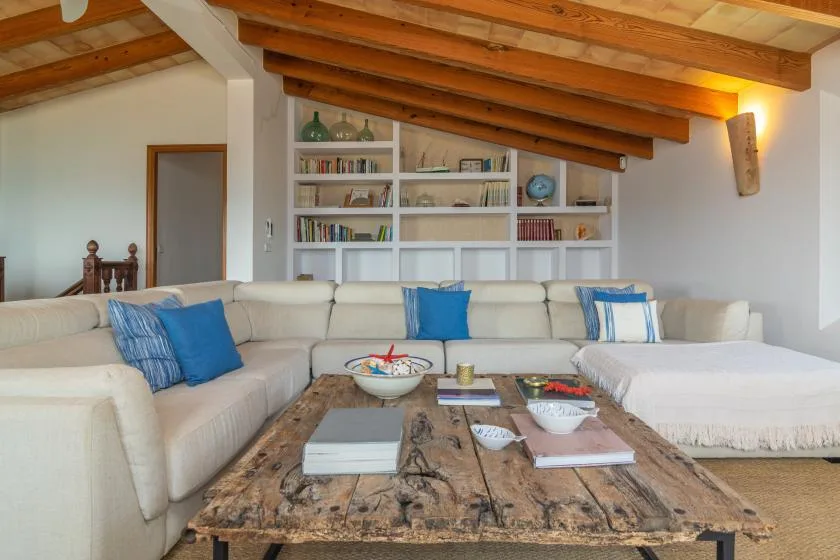 A living room with a cream sectional and a low wooden coffee table.