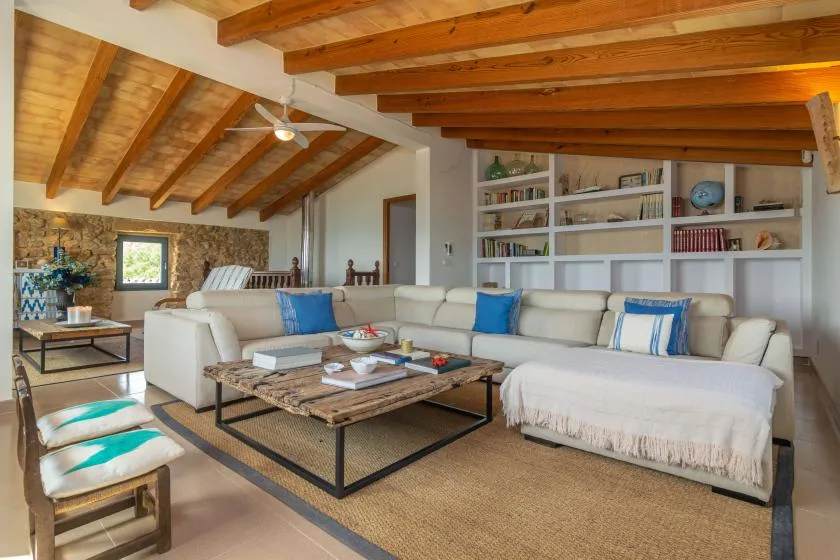 A spacious living room with seating, a low table, and built-in bookshelves.