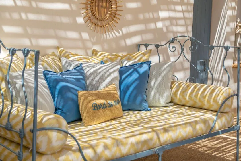 A sunlit seating nook with striped cushions and blue accent pillows.
