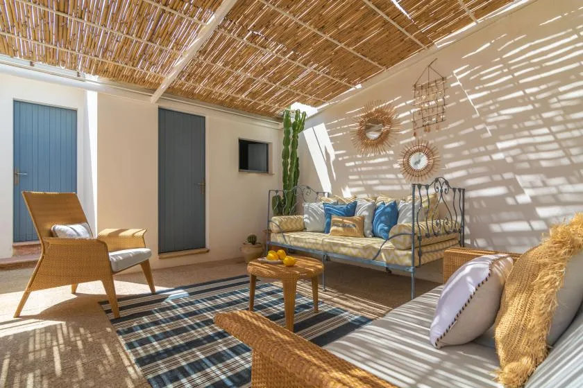 A bright lounge with cushioned seating beneath a woven canopy.