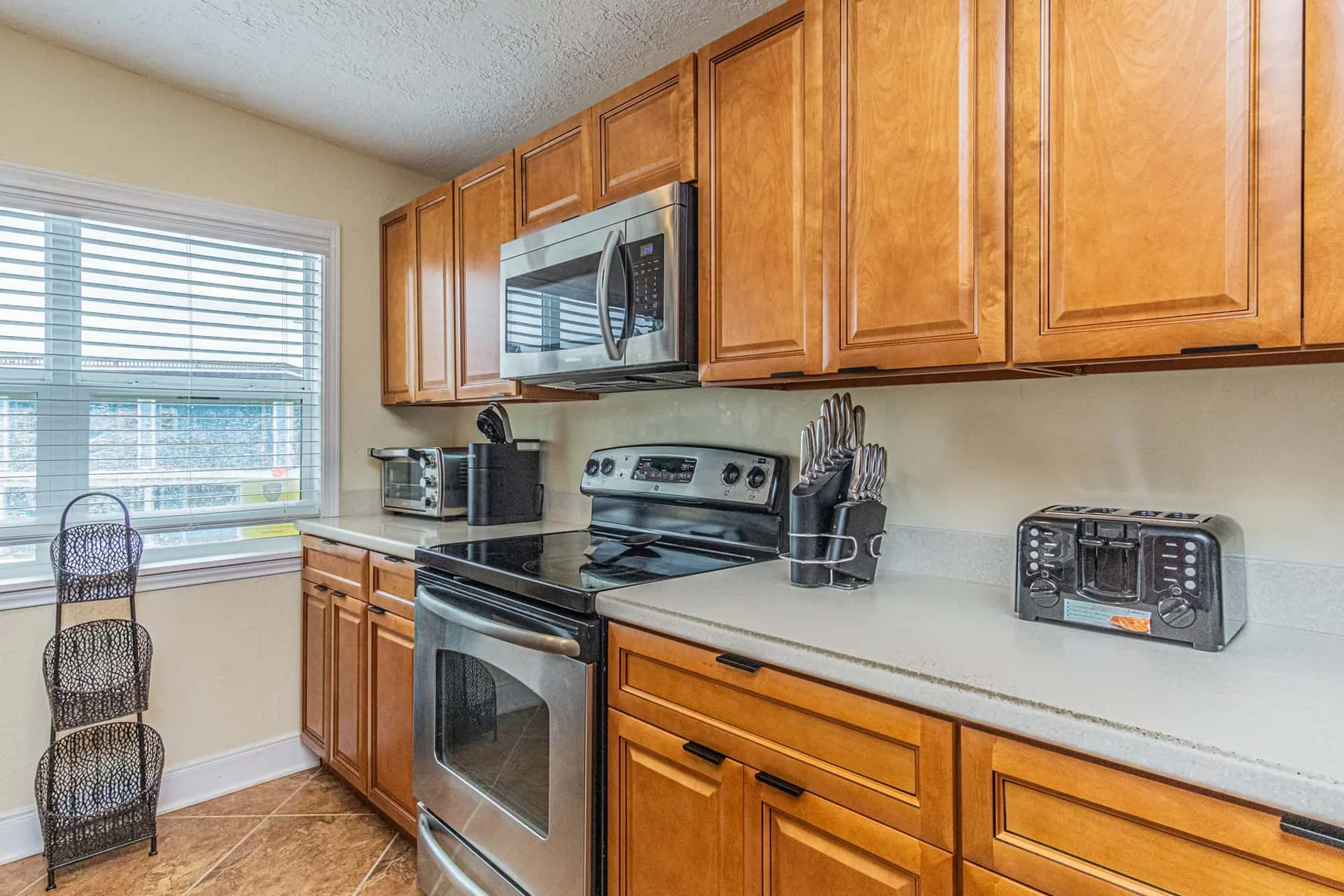 A kitchen with wooden cabinets, stainless steel appliances, and a countertop.