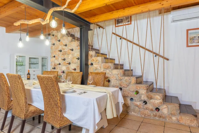 Un comedor con una mesa puesta junto a una escalera de piedra.