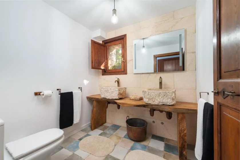 Un baño con una encimera larga, dos lavabos y un espejo.