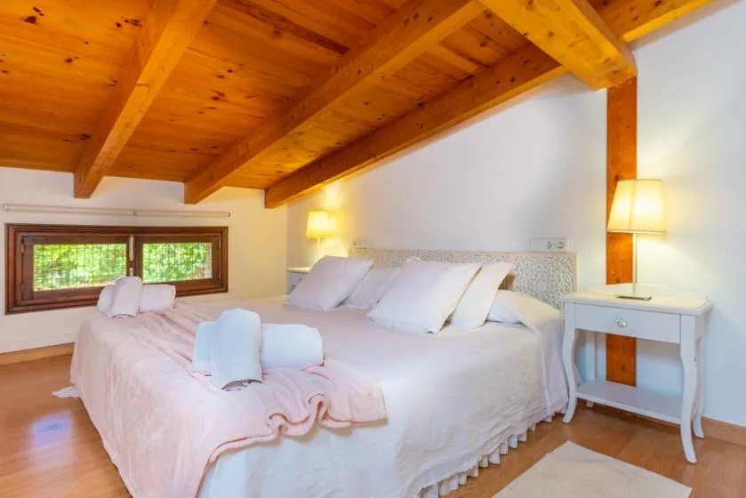 Un dormitorio con una cama grande bajo un techo de madera cálida.