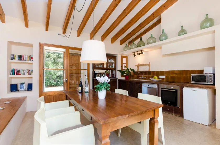 Comedor con una mesa de madera junto a la cocina.