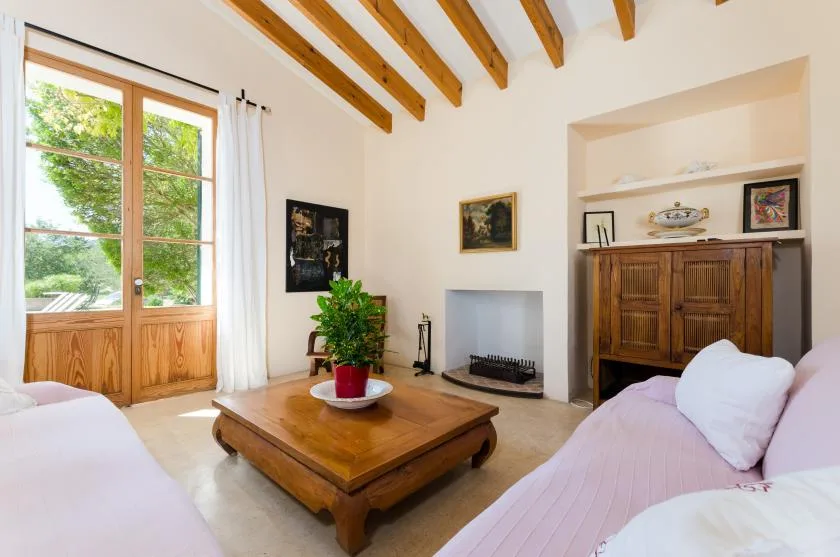 Un dormitorio luminoso con una mesa de centro de madera y una chimenea.