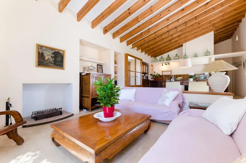 Una sala de estar luminosa con una mesa de centro de madera y vigas expuestas.