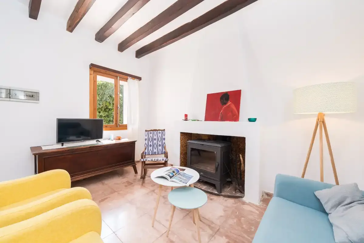 A living room with seating, a television, and a fireplace.