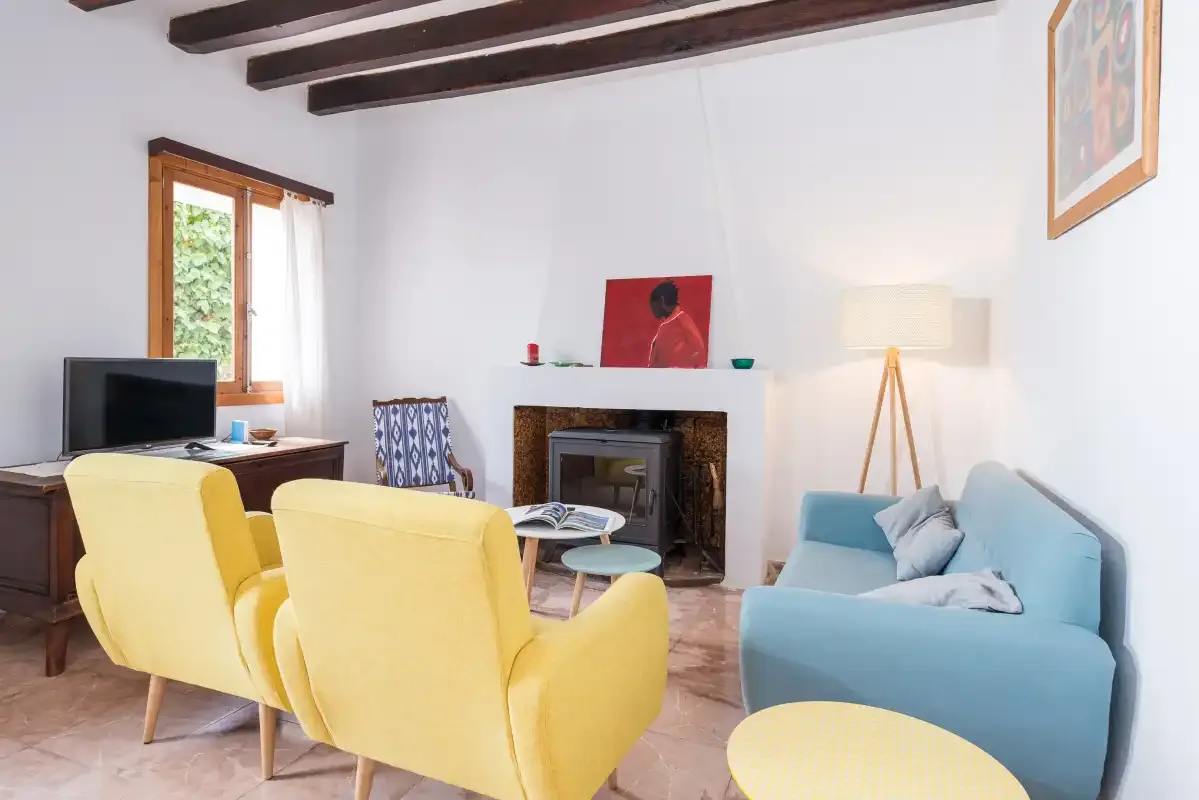 A living room with yellow seating, a blue sofa, and a fireplace.