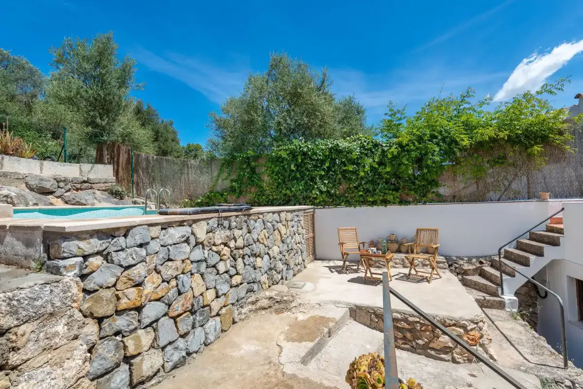 An outdoor patio with stone retaining walls, seating, and steps.