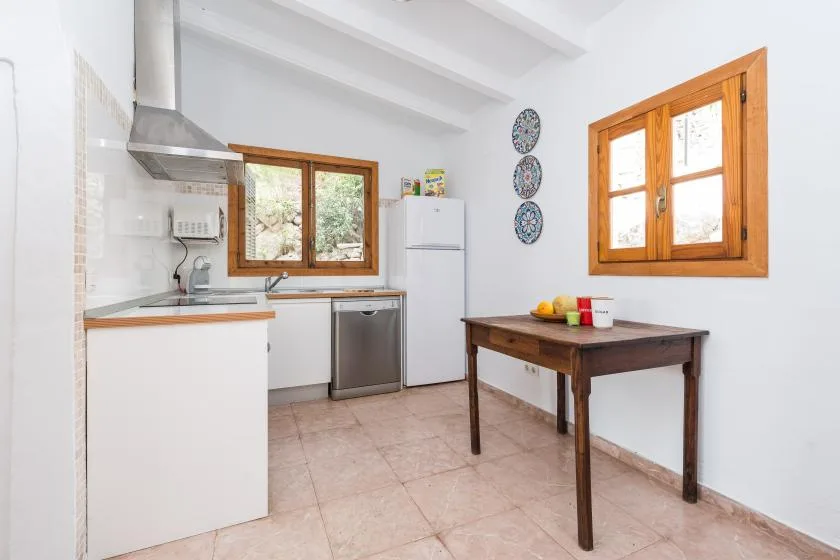 A bright kitchen with a wooden table and windows.