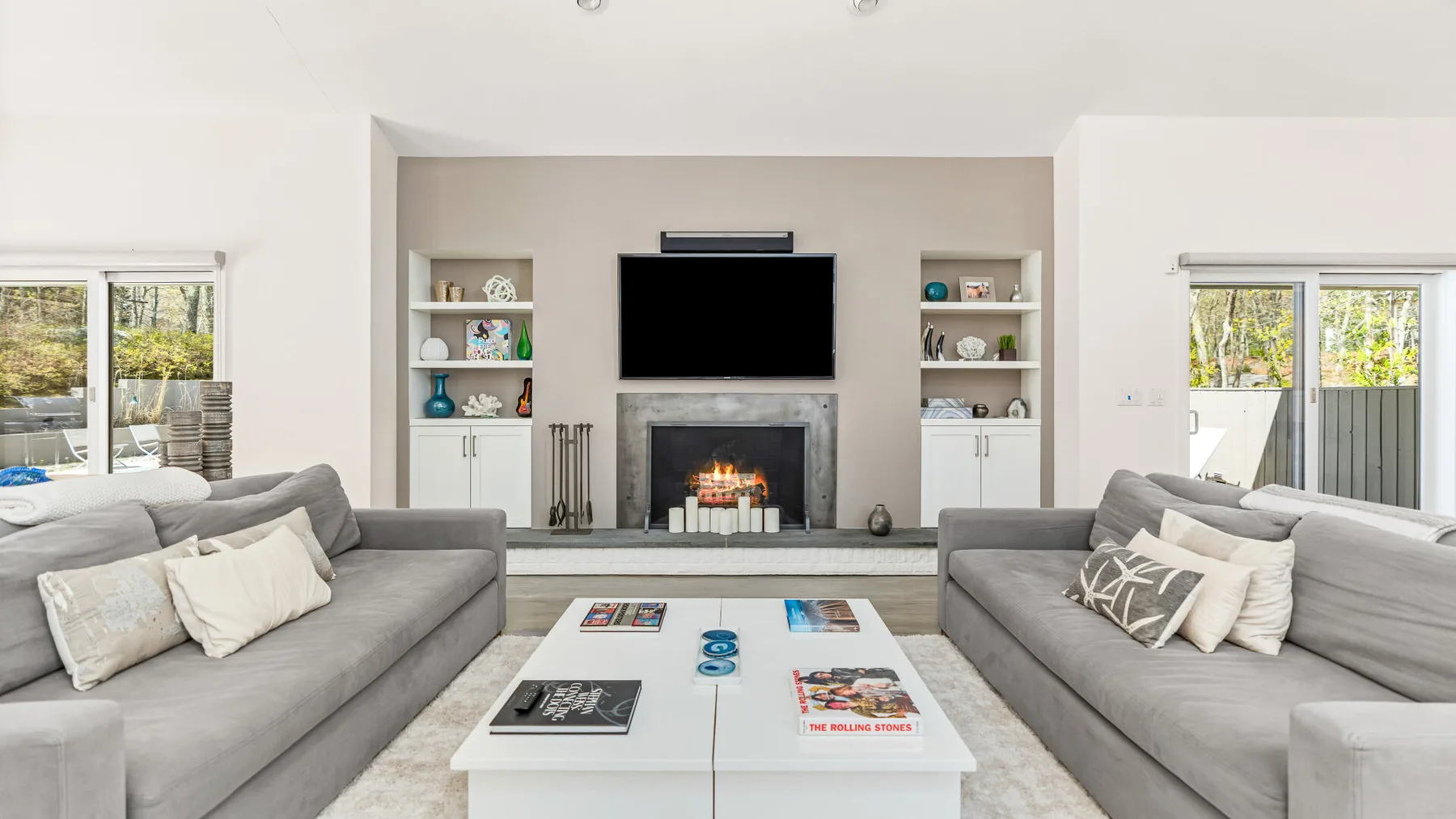 Una sala de estar con dos sofás frente a una chimenea y un televisor.