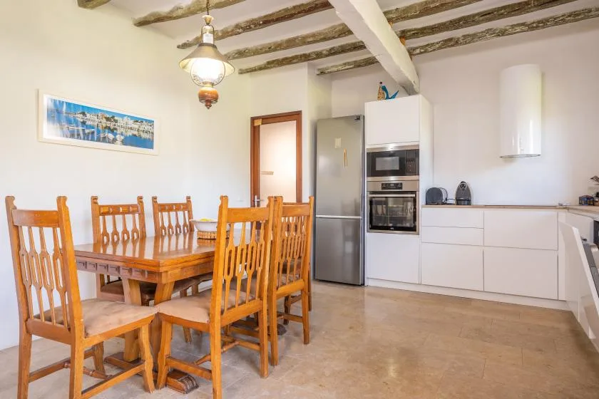 Un comedor con asientos de madera junto a una cocina moderna.