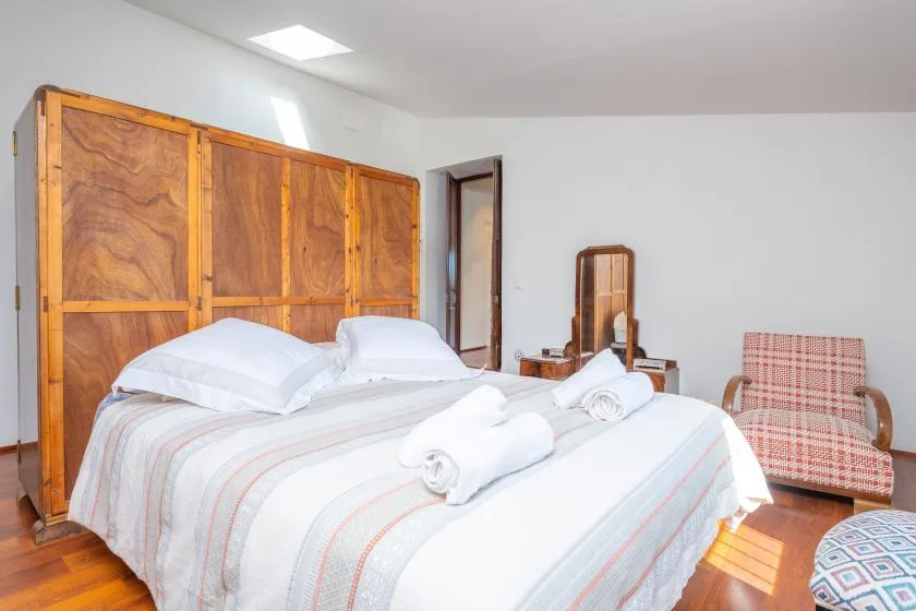 Un dormitorio con una cama bien tendida y toallas dobladas.