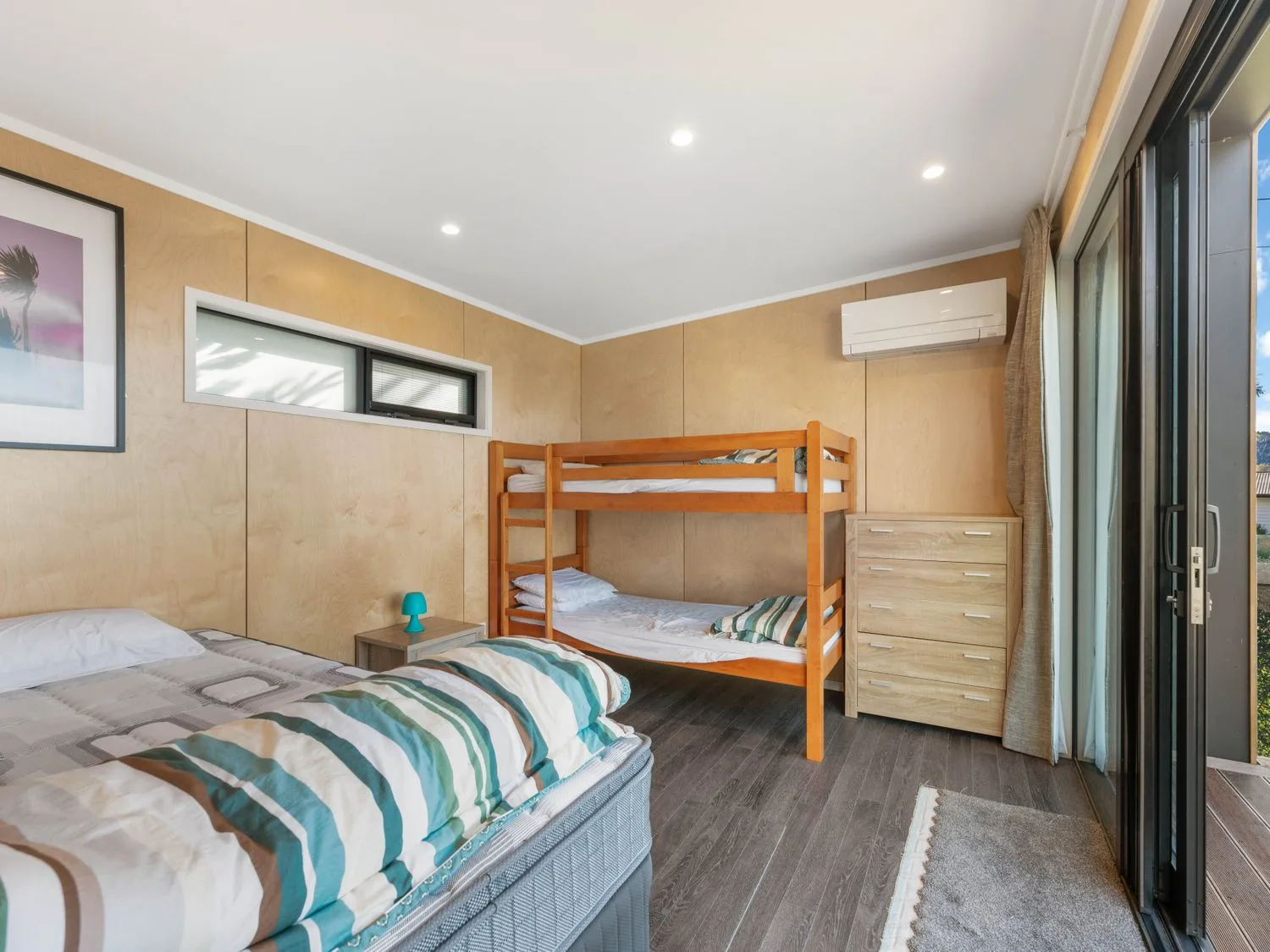 Un dormitorio con una cama doble, una litera, una cómoda de madera y una puerta corredera de vidrio en Henley - Omori Holiday Home, en Omori