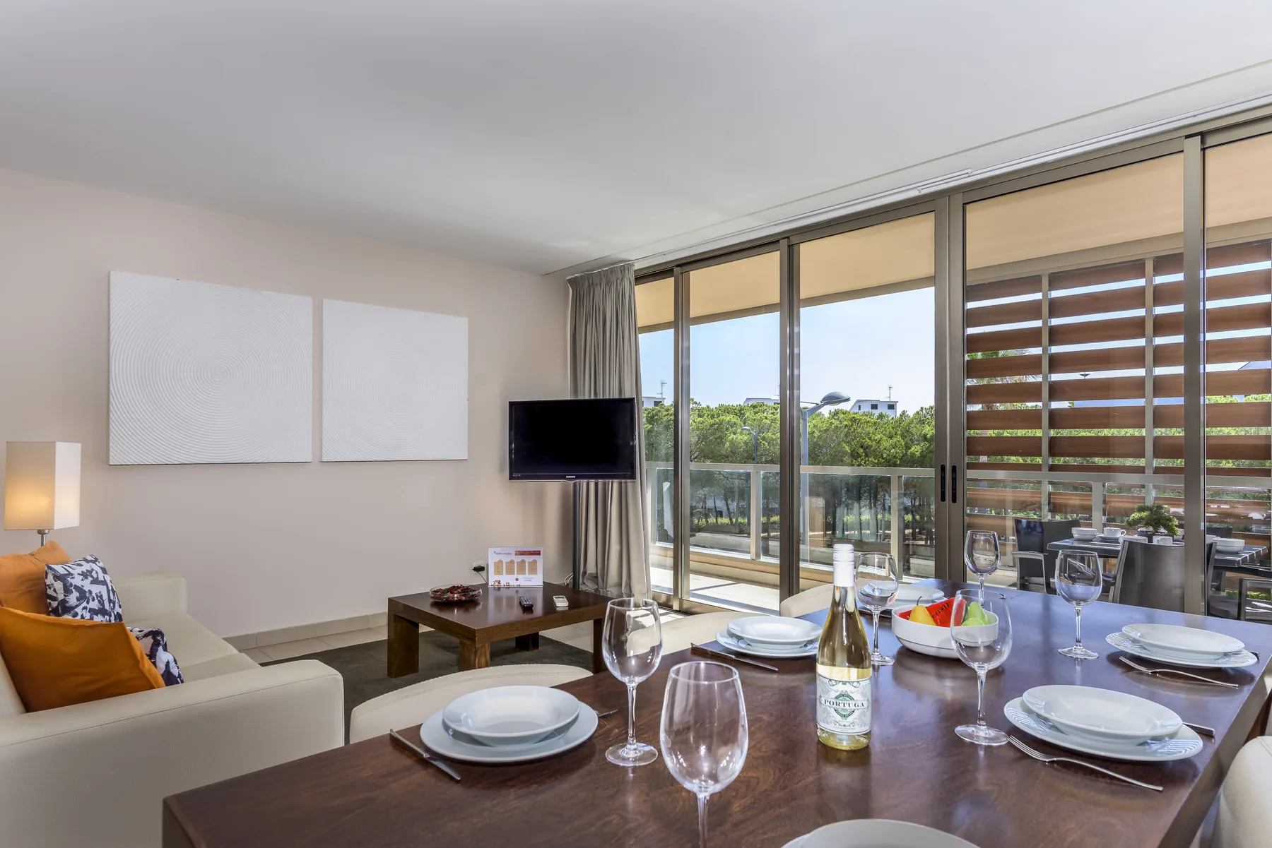 Una luminosa sala de estar y comedor se abre a un balcón con puertas corredizas de vidrio.