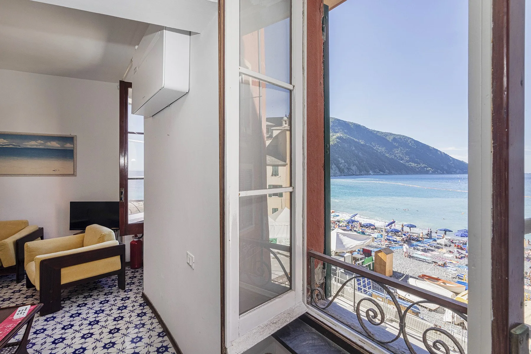 A sitting area opens onto a balcony overlooking the beach and water.