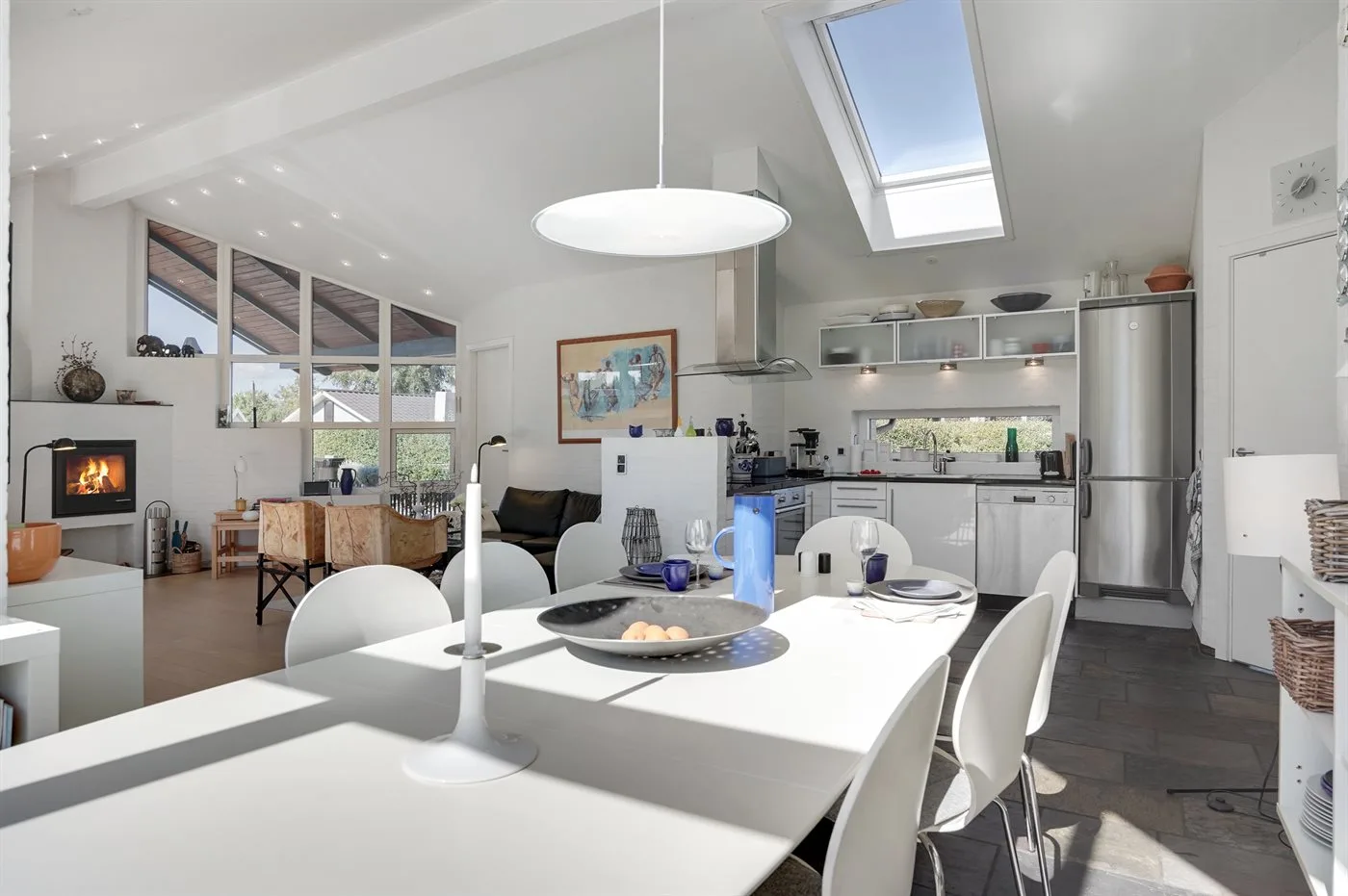 An open kitchen and dining area with a table and bright skylight.