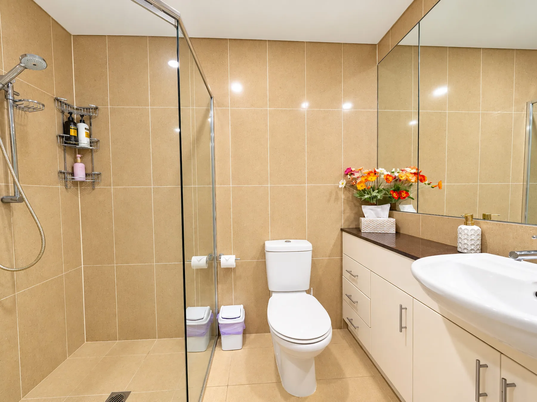A tiled bathroom with a shower, toilet, and sink.