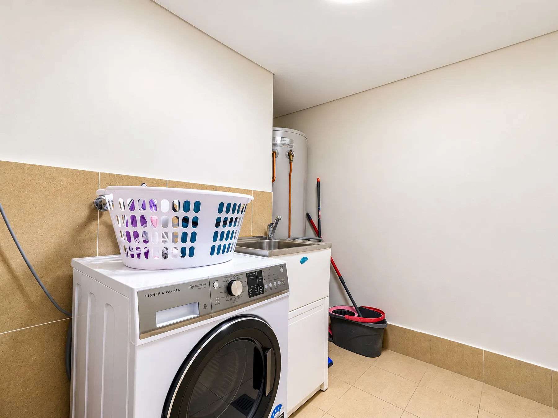 A laundry area with a washing machine and a basket of clothes.