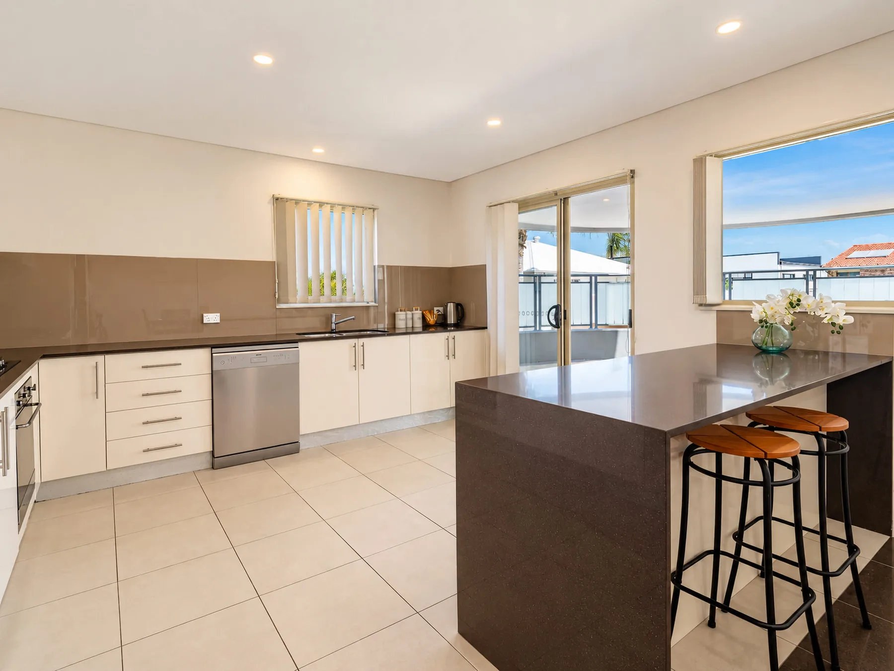 A bright kitchen with a central island and bar seating.